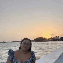 Karla Itzel Aguilar Vidal smiling and sitting in front of the sunset.